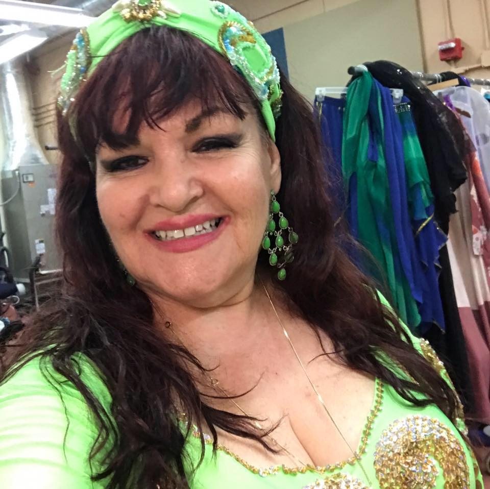Portrait of Jihan Jamal in green in a dressing room